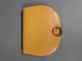 yellow leather wallet with a metal buckle on a gray surface