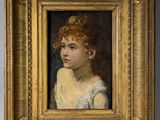 un tableau représentant une jeune fille en robe blanche, dans un cadre doré