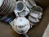 une boîte en carton remplie d'une multitude d'assiettes et de tasses en porcelaine