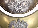 two brass collars with a picture of a bird on them