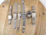 a lot of watches on a wooden board on a table