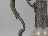 a silver and glass vase with a bird on it