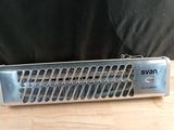 a silver and black electric heater on a wooden table