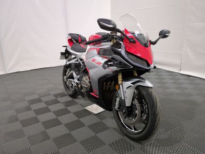 une moto rouge et noire garée sur un sol à damier noir et blanc
