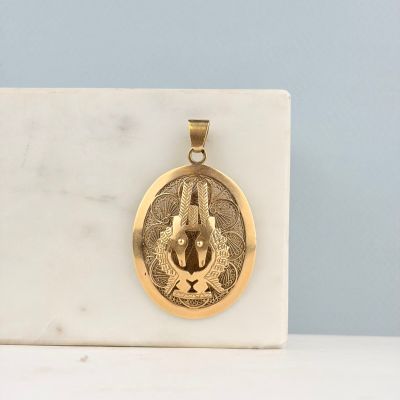 un pendentif plaqué or sur lequel est représenté un lapin