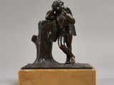 une statue en bronze représentant un homme assis sur une souche d'arbre