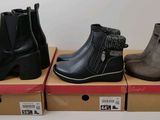 three pairs of women ' s ankle boots are on display in boxes
