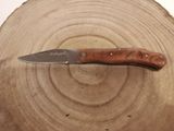 a knife that is sitting on top of a piece of wood