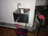 a sink and a bucket on the floor in a room