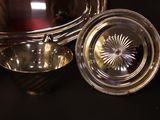 a silver bowl and a silver plate on a black table