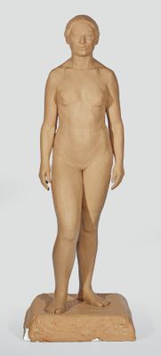 une statue en bois représentant un homme debout sur un socle