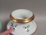 a person holding a cup and saucer in their hand