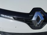 the front end of a white car with a black grille and a diamond emblem