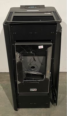 une photo d'un poêle noir dont la porte vitrée est cassée