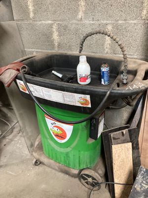 un seau vert avec une bouteille de produit nettoyant à côté