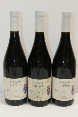 trois bouteilles de vin posées sur une table l'une à côté de l'autre