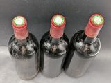 three bottles of wine sitting on top of a table next to each other
