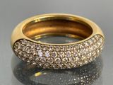 une photo d'une bague en or et diamants posée sur une table