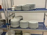 beaucoup d'assiettes et de bols sur les étagères de la cuisine