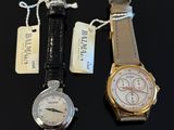 two watches are sitting next to each other on a table