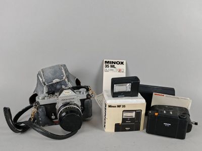 un appareil photo, un étui pour appareil photo, un appareil photo et d'autres objets posés sur une table