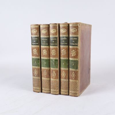 trois livres sont empilés sur une surface blanche