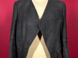 grey jacket on a mannequin dummy against a red wall