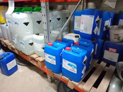 de nombreux conteneurs bleus et blancs posés sur une palette dans un entrepôt