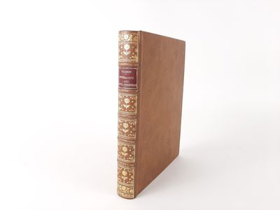an old book sitting on top of a white table next to a white wall