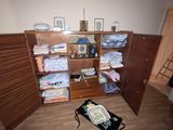 une pièce avec une bibliothèque et une valise posée par terre