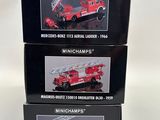 three boxed boxes of miniature fire trucks on a white surface