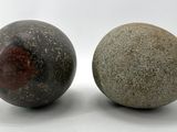 two rocks sitting next to each other on a white surface