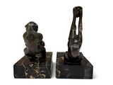 pair of bronze sculptures of a man and a woman on marble bases