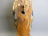 une vieille statue en bois représentant un homme avec une corde autour du cou