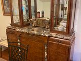 a dining room table with a glass top and a wooden china cabinet