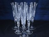 quatre verres à vin vides posés sur une nappe noire