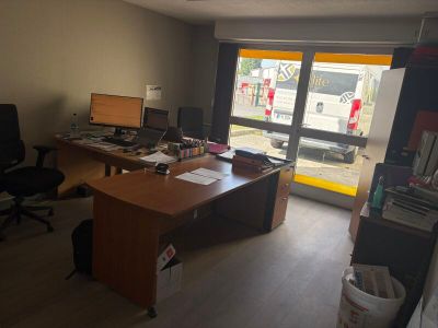 un bureau avec un ordinateur et une chaise dans une pièce