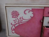 a picture of a pink dresser with a rose on it