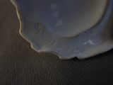 a close up of a white vase on a table