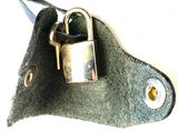 a close up of a metal padlock on a piece of leather