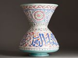 a vase with arabic writing on it sitting on a table