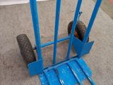 a blue hand truck that is sitting on the floor