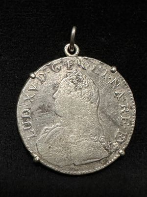 a close up of a silver coin on a black surface