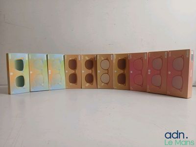 trois boîtes contenant des ombres à paupières de différentes couleurs, posées sur une surface blanche