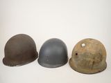 three helmets are lined up in a row on a white surface