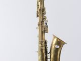 an old brass saxophone on a stand against a white background