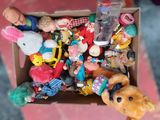a box full of stuffed animals and toys on a table