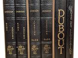 quatre livres sont alignés sur une surface blanche