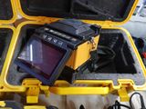 a yellow case with a monitor and other items in it