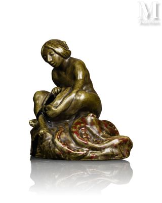 statue of a woman sitting on a rock holding a baby